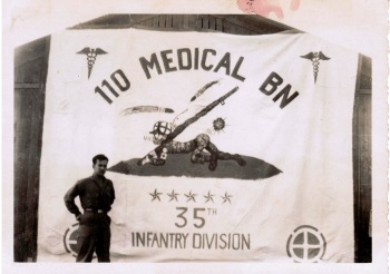 Gene Giordano with 110 Medical Bn Banner he made august 1945